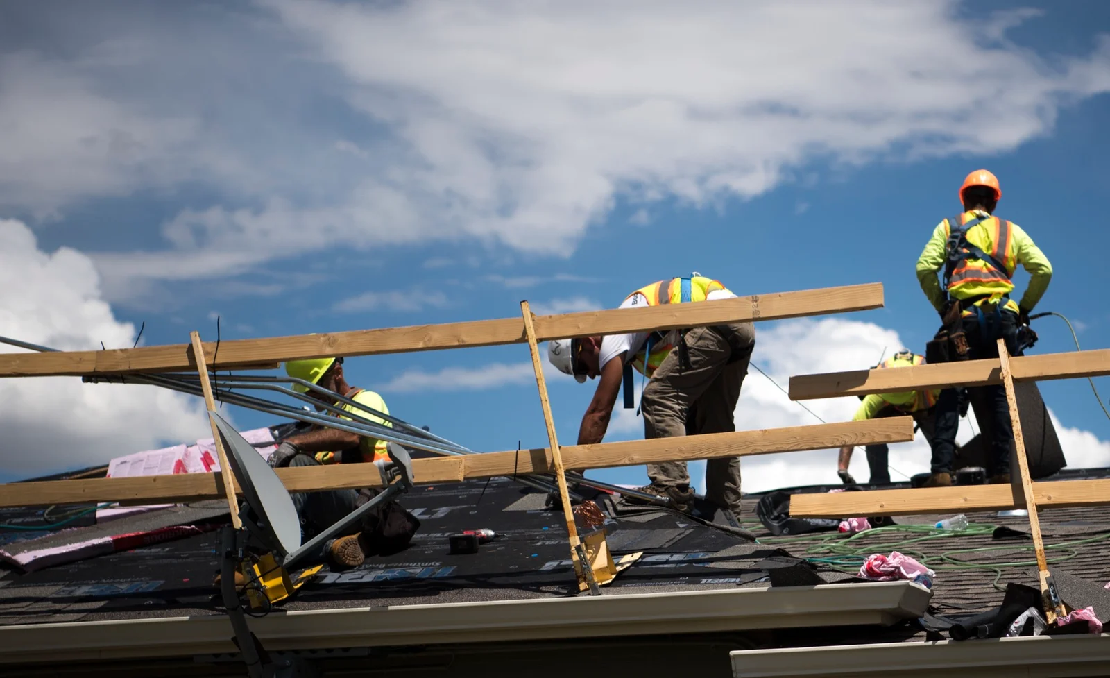 Roofing crew at work on exposed roof decking